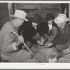 Men and boys examining seed at Gonzales County Fair. Gonzales, Texas