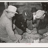 Men and boys examining seed at Gonzales County Fair. Gonzales, Texas