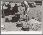 Cook of SMS Ranch making bread in front of chuck wagon. Ranch near Spur, Texas