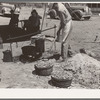 Cook of SMS Ranch making bread in front of chuck wagon. Ranch near Spur, Texas