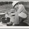 Cook of the SMS Ranch frying meat at chuck wagon on ranch near Spur, Texas