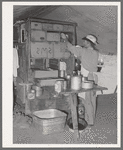 Cook of the SMS Ranch in front of the covered end of the chuck wagon. Ranch near Spur, Texas