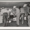 Cowboys of the SMS Ranch serving themselves at dinner at chuck wagon. Ranch near Spur, Texas