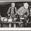 Cowboys of the SMS Ranch serving themselves at dinner at chuck wagon. Ranch near Spur, Texas