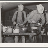 Cowboys of the SMS Ranch serving themselves at dinner at chuck wagon. Ranch near Spur, Texas