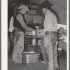 Cowboys of the SMS Ranch serving themselves at dinner at chuck wagon. Ranch near Spur, Texas