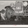 Migrant steeple-jack removing the crank case from his automobile while his father blocks up the front wheel. Near Prague, Oklahoma. When he secures a job, the entire family, consisting of his father and mother, wife and sister, all help with the painting