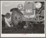 Migrant steeple-jack removing the crank case from his automobile while his father blocks up the front wheel. Near Prague, Oklahoma. When he secures a job, the entire family, consisting of his father and mother, wife and sister, all help with the painting