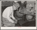 Father of migrant steeple-jack putting bolts in connecting rod while camped near Prague, Oklahoma. Lincoln County