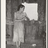 Daughter of agricultural day laborer looking out the unshuttered window of the desolate shack which was her home. She had never attended school