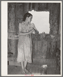 Daughter of agricultural day laborer looking out the unshuttered window of the desolate shack which was her home. She had never attended school