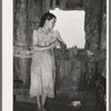 Daughter of agricultural day laborer looking out the unshuttered window of the desolate shack which was her home. She had never attended school