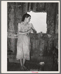 Daughter of agricultural day laborer looking out the unshuttered window of the desolate shack which was her home. She had never attended school