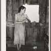 Daughter of agricultural day laborer looking out the unshuttered window of the desolate shack which was her home. She had never attended school