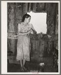 Daughter of agricultural day laborer looking out the unshuttered window of the desolate shack which was her home. She had never attended school