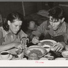 Two agricultural day laborers eating dinner after spending the morning chopping cotton. Beans are the staple fare of these workers. Near Webbers Falls, Oklahoma