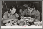 Two agricultural day laborers eating dinner after spending the morning chopping cotton. Beans are the staple fare of these workers. Near Webbers Falls, Oklahoma