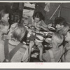 A family of agricultural day laborers eating dinner after a morning spent in chopping cotton. Though the fare of these people consists of the inexpensive and heavy starches, it is usually well prepared