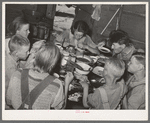 A family of agricultural day laborers eating dinner after a morning spent in chopping cotton. Though the fare of these people consists of the inexpensive and heavy starches, it is usually well prepared