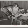 Young migrant girl sitting on the corner of bed in camp house near Muskogee, Oklahoma. Muskogee County