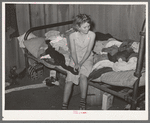 Young migrant girl sitting on the corner of bed in camp house near Muskogee, Oklahoma. Muskogee County