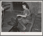 Wife of tenant farmer freezing ice cream on porch of her home near Warner, Oklahoma