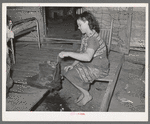 Wife of tenant farmer freezing ice cream on porch of her home near Warner, Oklahoma