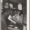 Migrant woman peeling potatoes on running board of car while camped near Prague, Oklahoma. Lincoln County, Oklahoma