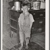 Child of white tenant farmer in kitchen of his home. McIntosh County, Oklahoma. Notice the pail of lard