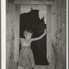 Daugher of day laborer standing in the window of her home in McIntosh County, Oklahoma