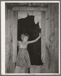 Daugher of day laborer standing in the window of her home in McIntosh County, Oklahoma