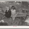 Children of agricultural day laborer sitting on an old automobile seat cushion. On Poteau Creek near Spiro, Oklahoma, Sequoyah County