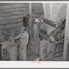 Filling bags with feed made from peanut shells and blackstrap molasses. Peanut-shelling plant. Comanche, Texas