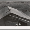 Pipe which conveys peanut shells into mixing room. Peanut-shelling plant. Comanche, Texas. The peanut shells are gound up and then mixed with blackstrap molasses and are used as livestock feed