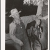Farmer unloading turkeys from his truck at cooperative poultry house. Brownwood, Texas