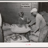 Handling sacks of cotton seed cake meal at cotton seed oil mill. McLennan County, Texas