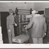 Weighing box of turkeys to be loaded into freight car at cold storage plant. Brownwood, Texas. Sheepskin coat is necessary because of low temperature in cold storage plant