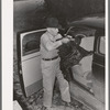 Farmer removing turkey from his car which he has brought to the cooperative poultry house. Brownwood, Texas