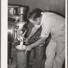 Filling can with ice cream mix. Creamery, San Angelo, Texas. Later it will be placed in freezer