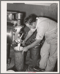 Filling can with ice cream mix. Creamery, San Angelo, Texas. Later it will be placed in freezer