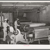 Formation of cotton bat for stuffing mattresses. Mattress factory. San Angelo, Texas. This bat is usually made from cotton linters which is that part of the cotton closest to the seed. Dark in color and short of staple