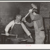 Blacksmith and helper pounding out plow point. Depew, Oklahoma