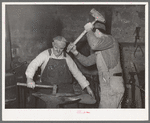 Blacksmith and helper pounding out plow point. Depew, Oklahoma