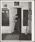 Elderly farm woman arriving at pie supper with her pie which will be sold at auction. Muskogee County, Oklahoma. See general caption number 24