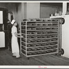 Moving trayload of bread and rolls into the rising compartment, which has regulated temperatures. Bakery, San Angelo, Texas