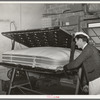 Getting ready to tuft a mattress in clamping machine. Mattress factory, San Angelo, Texas