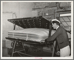 Getting ready to tuft a mattress in clamping machine. Mattress factory, San Angelo, Texas