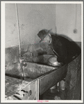 Farmer cleaning out milk can. Creamery, San Angelo, Texas