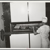 Placing rolls in reel oven to be baked. Bakery, San Angelo, Texas