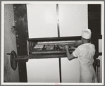 Placing rolls in reel oven to be baked. Bakery, San Angelo, Texas